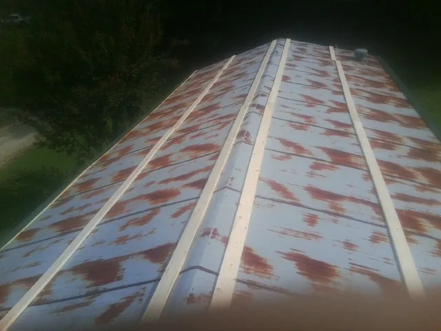 Rusted metal roof panels with new wood purlins before replacement — Storm Damage Roof Repair in Leroy by Roofing Brothers