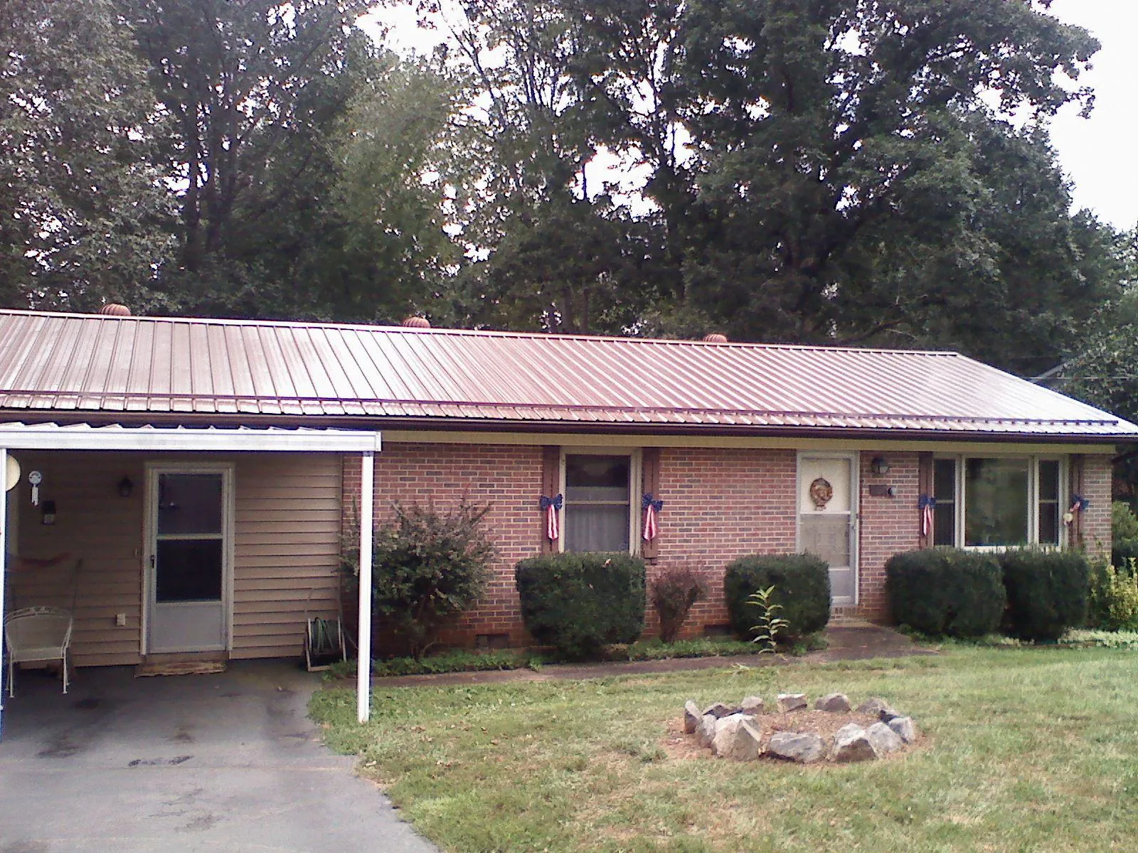 Bronze metal roof and carport on a brick ranch home — Roof Repair work by our crew in Leroy